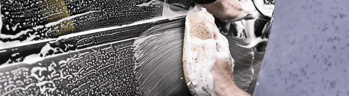 a man washing a car with a sponge