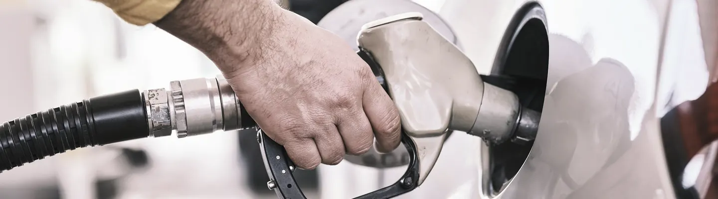 a man pumping gas into his car at a gas station