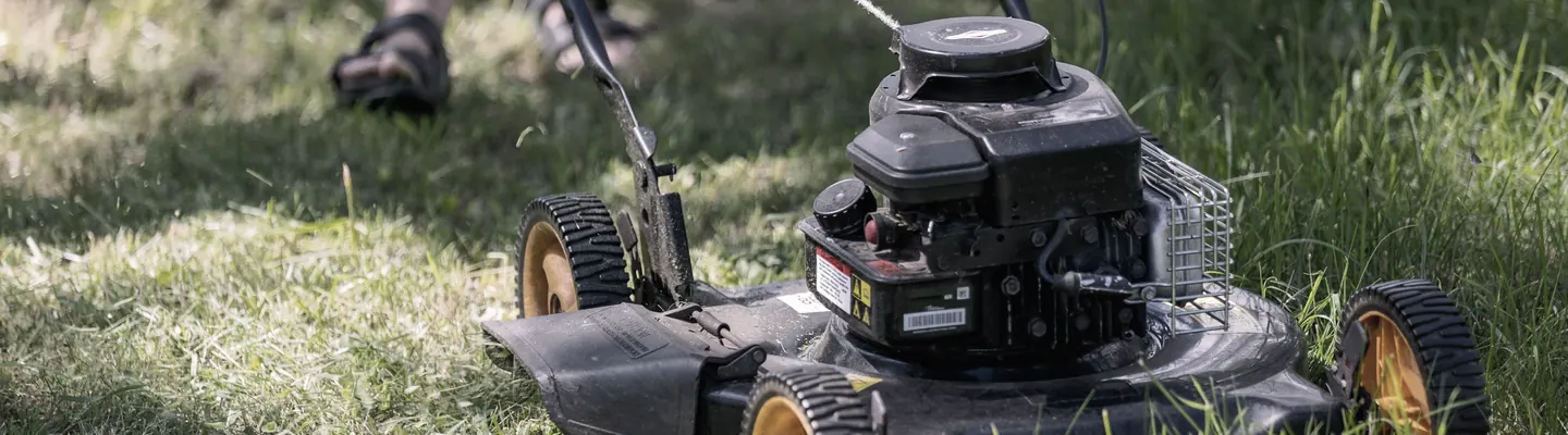a person mowing the grass with a lawn mower