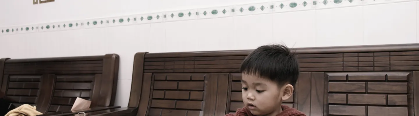 A young boy plays with toys on a table