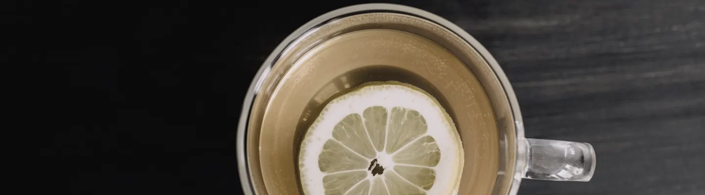a cup of tea with a lemon slice in it