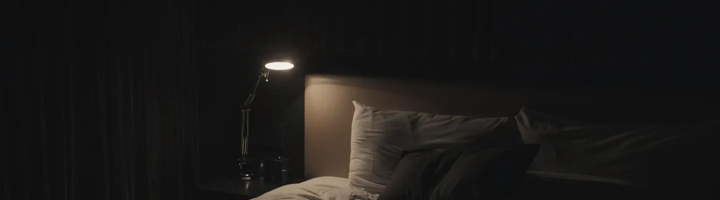 table lamp turned-on near bed