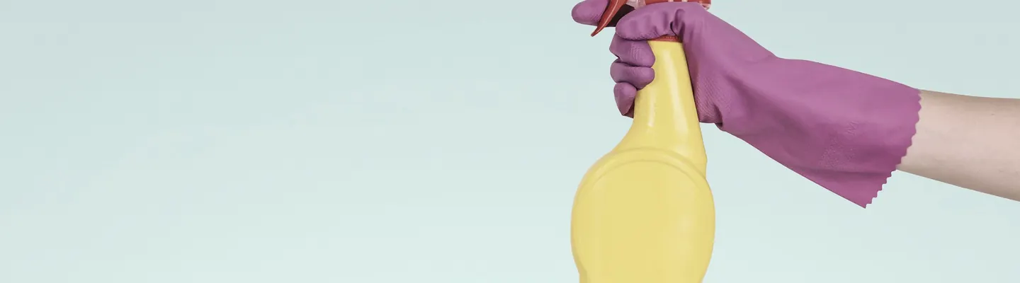 person holding yellow plastic spray bottle